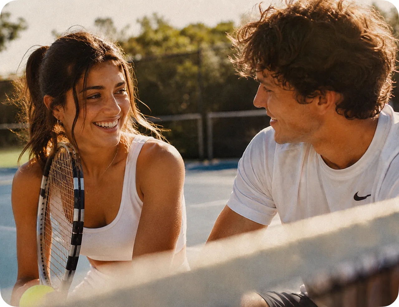 Two people talking on a tennis court